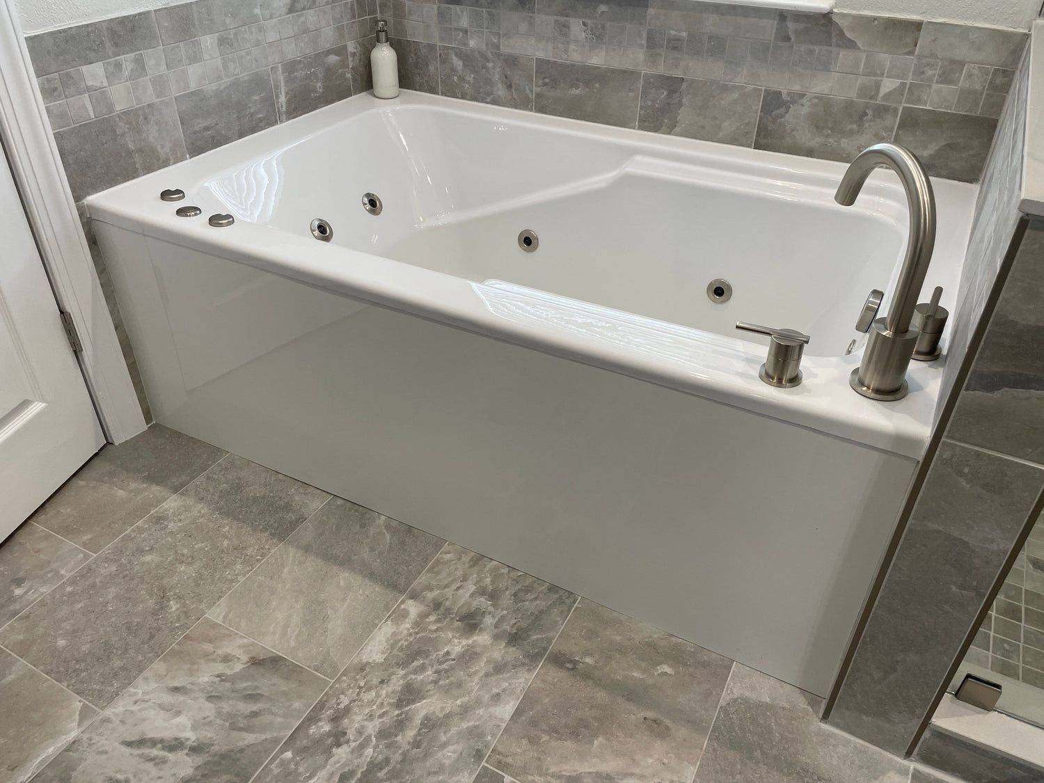 Installed 66-inch WaterTech bathtub in a tiled bathroom