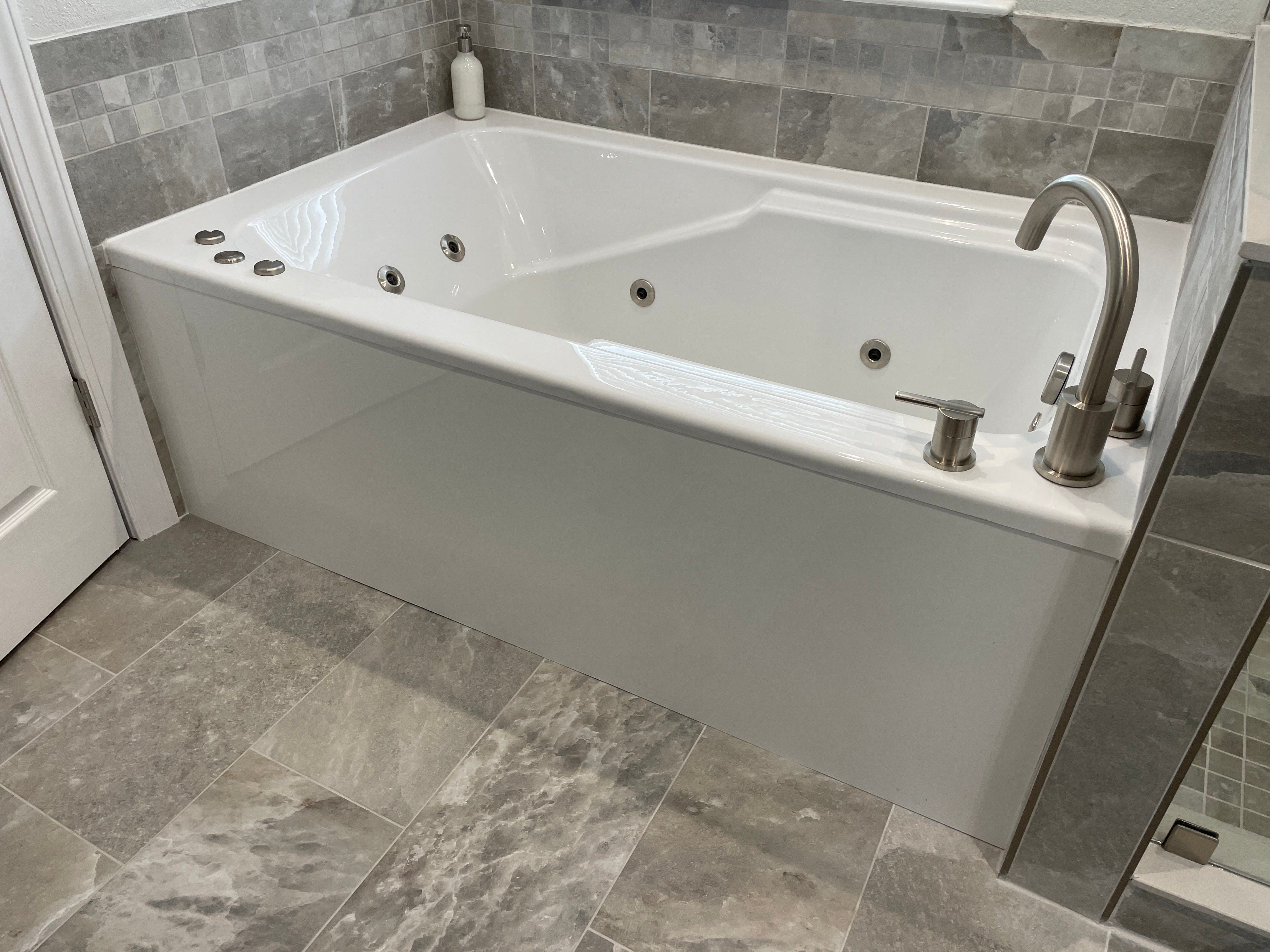 Installed 66-inch WaterTech bathtub in a tiled bathroom